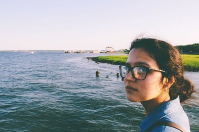 Portrait of young woman in sea against clear sky