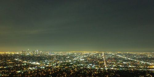 High angle view of illuminated cityscape against sky at night