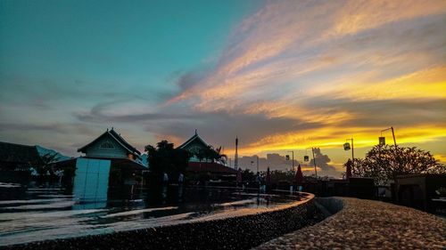 Houses and buildings against sky at sunset