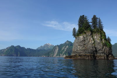 Scenic view of sea and mountains against blue sky