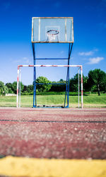 Basketball court against trees and blue sky