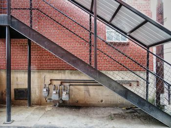 Metal staircase against exterior brick wall