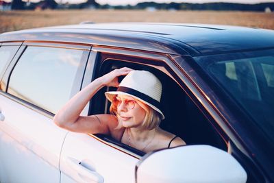 Smiling beautiful woman looking car window