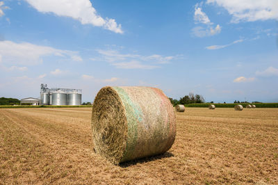 Hay bales on field against sky