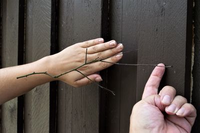 Cropped image of hand holding metal fence