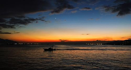 Silhouette of boat in sea during sunset