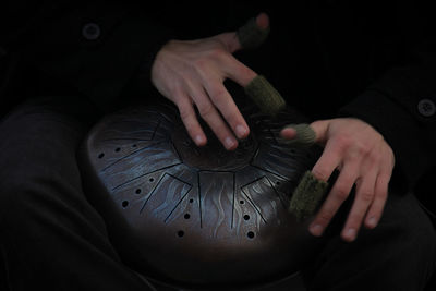 Close-up of person holding box black background