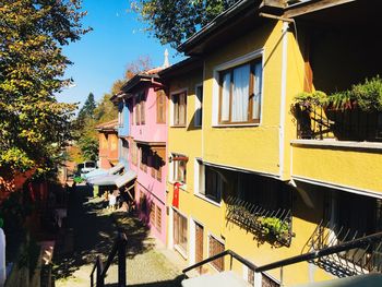 Houses by canal against sky in city