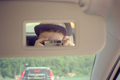 Man photographing through smart phone in car