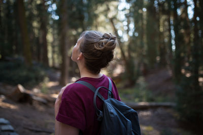 Close-up of backpack female hiker standing in forest