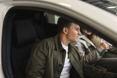 Customers trying car in car dealership office