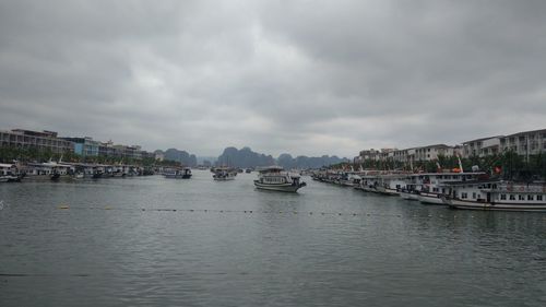 Boats in sea against sky in city