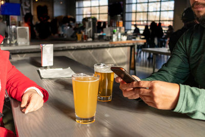 Midsection of couple sitting at bar