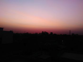 Silhouette cityscape against sky during sunset