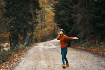 Full length of man standing on road in forest