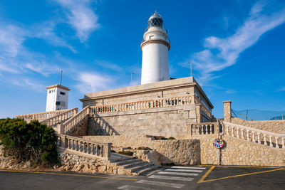 Lighthouse by sea against sky