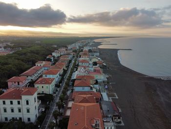 High angle view of townscape by sea against sky during sunset