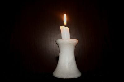 Close-up of lit candle in dark room