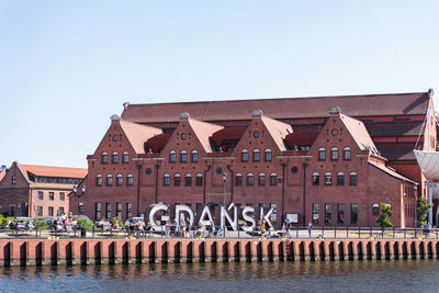 Group of people at beach against clear sky