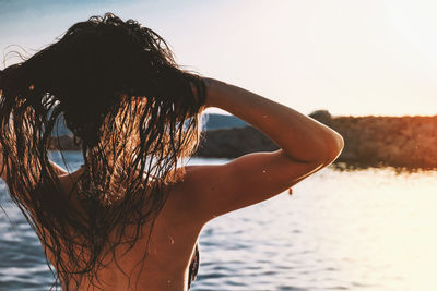 Rear view of woman in sea against sky