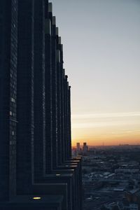 Modern buildings against sky during sunset