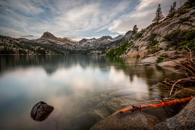 Scenic view of lake by mountains against sky