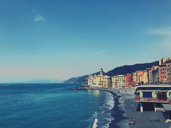 Scenic view of sea by buildings against sky