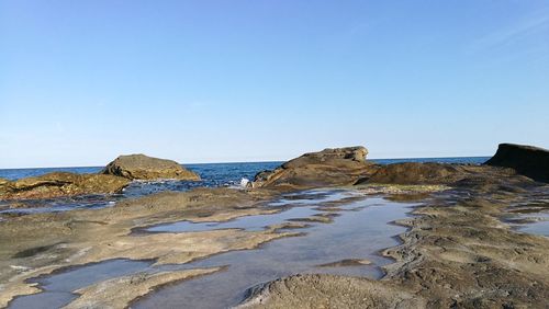 Scenic view of beach against clear blue sky