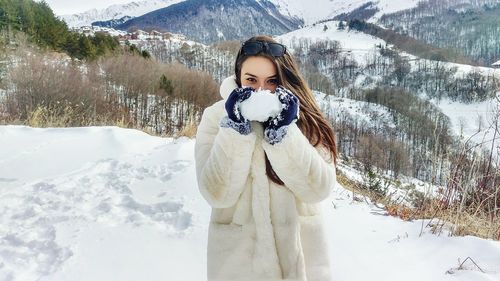 Portrait of young woman standing in snow