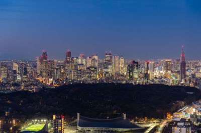 Illuminated buildings in city against sky at night