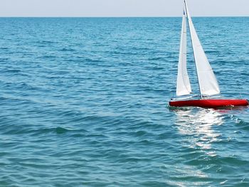 Sailboat in sea against sky