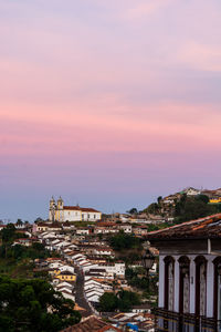 Buildings in town against sky at sunset