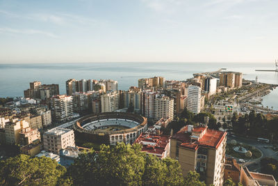 High angle view of buildings by sea against sky