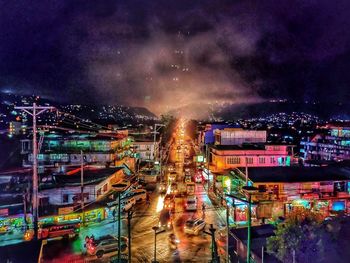 High angle view of illuminated city against sky at night