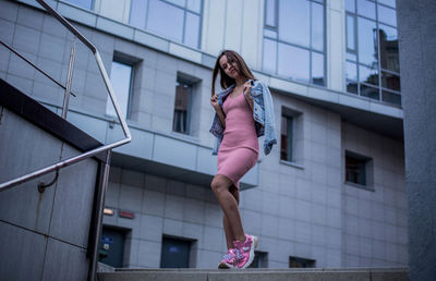 Full length portrait of woman against building