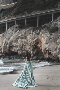 Man standing on rock at beach
