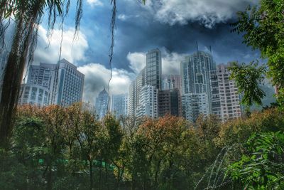 Low angle view of modern buildings against cloudy sky