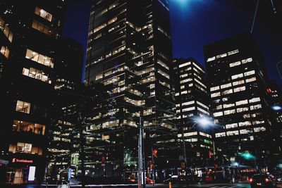 Low angle view of illuminated city against sky at night