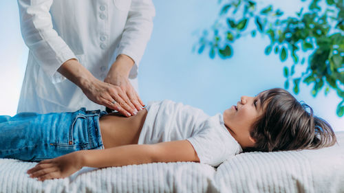 Low section of woman lying on bed