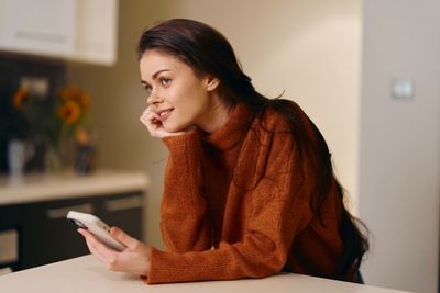 Young woman using mobile phone at home