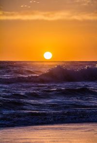 Scenic view of sea against orange sky