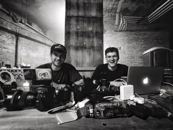 Full length portrait of man sitting on table