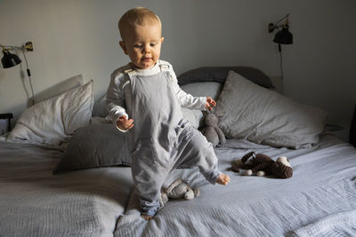 Baby boy walking on bed barefoot