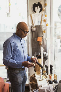 Senior customer looking at candlestick holder in store