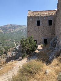 Plants growing on old building against sky
