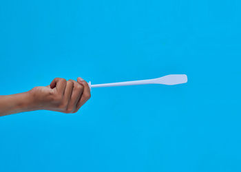 Close-up of woman hand against blue background