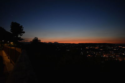 Silhouette buildings against clear sky at sunset