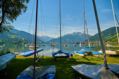 Sailboats moored in lake against sky