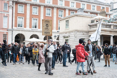 People walking on street against buildings in city