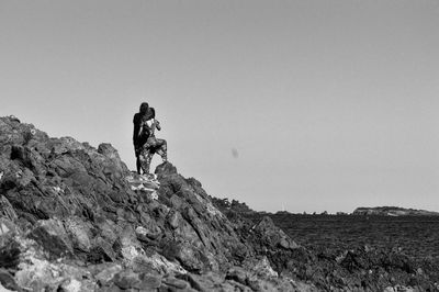 Low angle view of people walking on mountain against sky